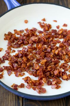 chopped bacon in a skillet on a wooden table