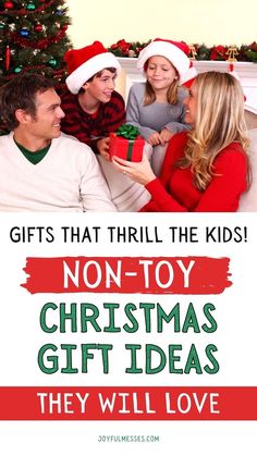 two kids and an adult sitting on a couch with christmas gifts in front of them