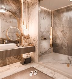 a bathroom with marble walls and flooring in gold, white and grey colors is shown