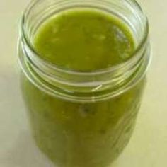 a jar filled with green liquid sitting on top of a table