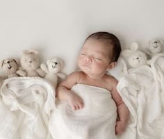 a baby is sleeping with stuffed animals around him