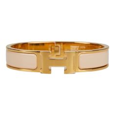 This Clic Clac H bracelet is in Beige Nacre enamel with gold plated hardware. Origin: France Condition: Pristine; new or never worn (plastic on hardware) Accompanied by: Hermes box, Hermes dustbag, carebook Measurements: Diameter: 2.25"; Circumference: 7"; Width: .5" Hermes Clic H Bracelet, Unrealistic Wishlist, Beige Jewelry, H Bracelet, Hermes Bracelet, Hermes Jewelry, Hermes Box, Enamel Bracelet, Hermes Bags