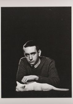 a black and white photo of a man holding a cat