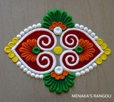 an intricately designed design on the wall in front of a wooden surface with white beads and green leaves