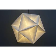 a white origami light hanging from a ceiling