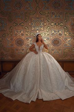 a woman in a wedding dress is standing on the floor with her back to the camera