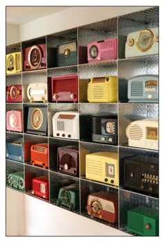 there are many radio's on the shelves in this room, all different colors