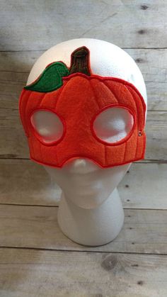 a white mannequin head with a pumpkin mask on it