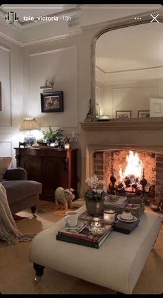 a living room filled with furniture and a fire place next to a mirror on the wall