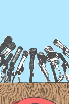 a bunch of microphones sitting in front of a wooden table