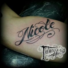 a tattoo with the word nicole on it's arm and handwritten name in cursive writing