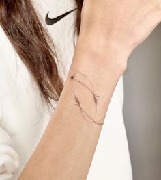 a woman wearing a nike wristband with a small tattoo on her left arm,