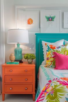 a bedroom with colorful bedding and pictures on the wall