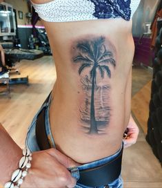 a woman with a palm tree tattoo on her stomach