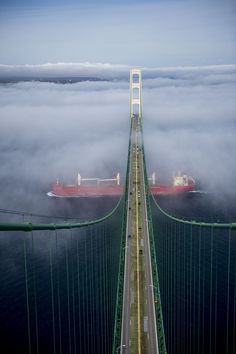 a long bridge that is surrounded by clouds