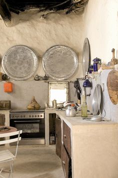 an old fashioned kitchen with two plates hanging on the wall above the stove and table