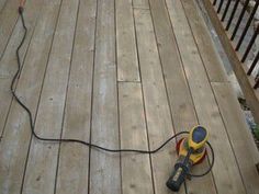 a corded sanding machine sitting on top of a wooden deck