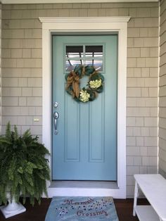 a blue front door with two wreaths on it