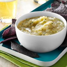 a bowl of soup with potato chips on the side