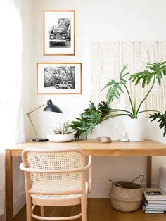 a wooden table topped with potted plants next to a wall mounted art piece on the wall