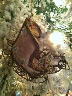 an ornament hanging from a christmas tree in the shape of a sleigh