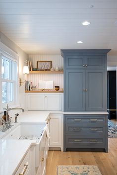 a kitchen with blue cabinets and white counter tops