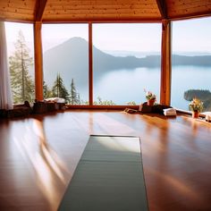 a yoga mat on the floor in front of a large window overlooking water and mountains