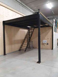 an empty garage with ladders to the ceiling and stairs on the wall next to it