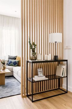 a living room filled with furniture and a wooden slatted wall behind the couch