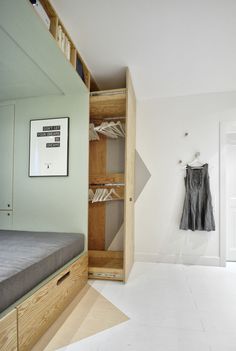 an empty room with a bed, closet and clothes hanging on the door hangers