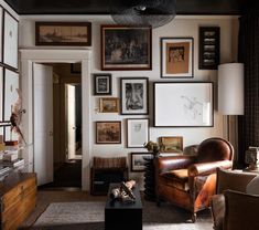 a living room filled with furniture and pictures on the wall