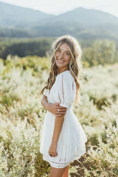 a woman standing in the middle of a field