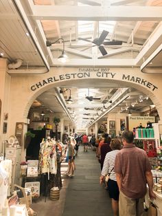 people are walking through charleston city market, which is open to the public for business