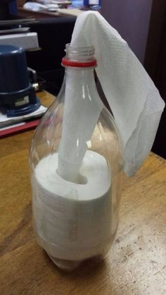 a glass bottle with a tissue paper in it sitting on top of a wooden table