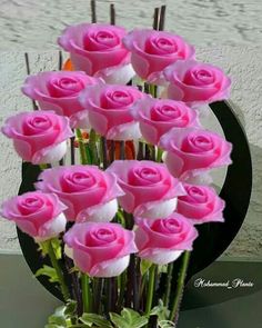 a vase filled with pink roses on top of a table