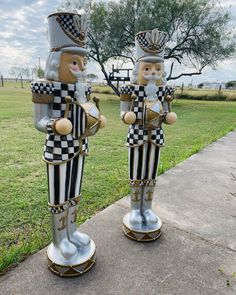 two large metal nutcrackers standing next to each other in front of a tree