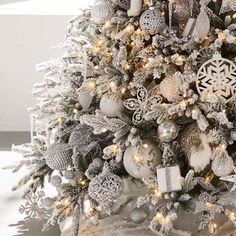 a decorated christmas tree with silver and white ornaments