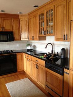 a kitchen with wooden cabinets and black appliances