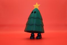 a small green christmas tree with a star on it's top and legs, standing in front of a red background