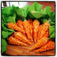 carrots wrapped in plastic sitting on top of a wooden table