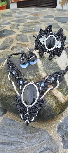 two black and white necklaces sitting on top of a rock