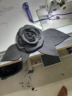 a person is working on a flower made out of paper and fabric with sewing machine in the background