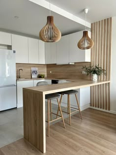 a kitchen with white cabinets and wooden counter tops, two stools at the island