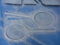 two tennis racquets on a blue and white background