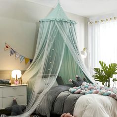 a bedroom with a canopy bed and lots of stuffed animals on the floor next to it