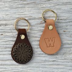 two leather keychains with the letter w on them