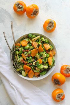 a bowl full of brussels sprouts and oranges with text overlay that reads brussel sprouts + persimon fall harvest salad