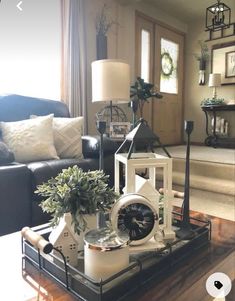 a living room filled with furniture and a clock on top of a table in front of a window