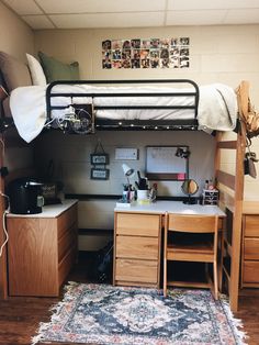 a loft bed with desk underneath it in a room that has wood flooring and white walls