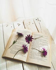 an open book with purple flowers on it